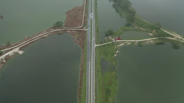 Aerial view of rural road through abandoned tin mine ponds in Kampar, Perak, Malaysia