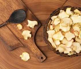 dried apples in a bowl on a wooden table. diet food