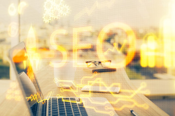 Multi exposure of table with computer and seo drawing hologram. Search optimization concept.