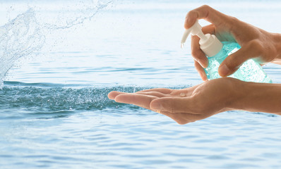 Hand of man using  hand sanitizer jel with water splash background
