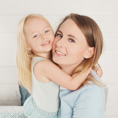 Closeup portrait of cute mother and little daughter cuddling