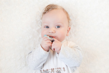cute baby with pacifier on a white blanket