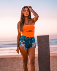 Lifestyle, a beautiful long-haired brunette in a sunset on the beach