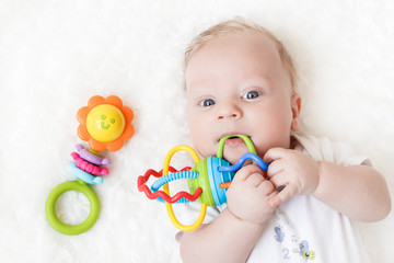four-month-old boy chewing a rattle