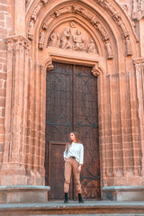 Obraz na płótnie Canvas Lifestyle, a young caucasian blonde at the giant door of a church