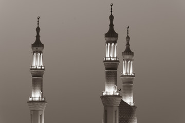 Fototapeta na wymiar Islamic mosque spires in black and white echos prayer calls at night. Muslim, ramadan, religion concepts.
