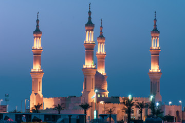 Sheikh's Zayed's Mosque glowing colors in Ras al Khaimah, UAE at night echos prayer call along the ...