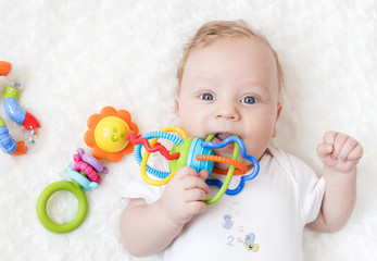 four-month-old boy chewing a rattle