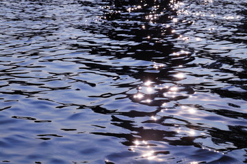 The surface of the water in the lake with solar glare.