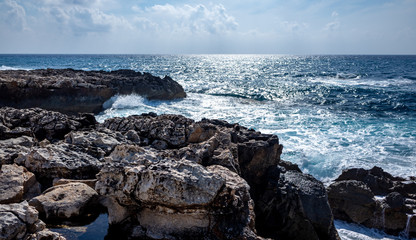 Fototapeta na wymiar Waves crash on the rocky shore of the Mediterranean Sea on the Akamas Peninsula in the northwest of the island of Cyprus.