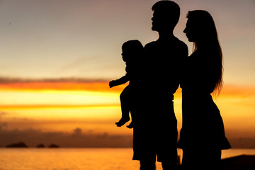 family silhouette at sunset with son