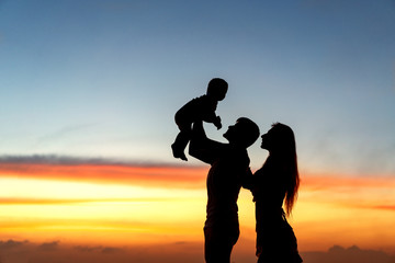 family silhouette at sunset with son