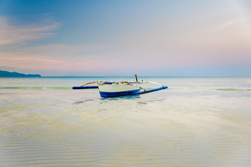 Small boat at the shore of Boracay, Philippines during early morning low tide