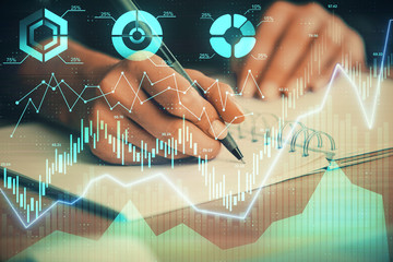 Forex graph on hand taking notes background. Concept of research. Double exposure