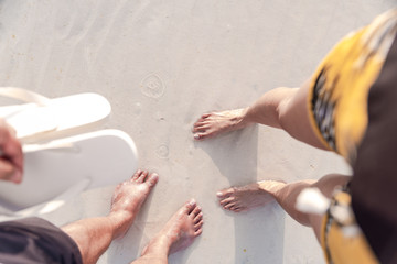 Top view of couples feet enjoying the powdery white sand of Boracay, Philippines