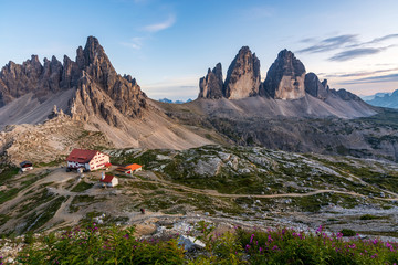 Famous mountains Three Peaks in the Dolomites with the alpine hut Dreizinnenhuette during sunset