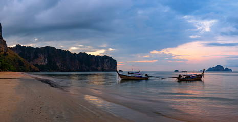Naklejka premium Traditional long-tail boat on the beach in Thailand at sunset