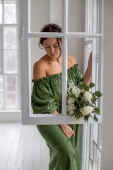 vertical portrait of a brunette by the open window