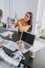 Obraz premium Happy pretty woman is pointing her finger up