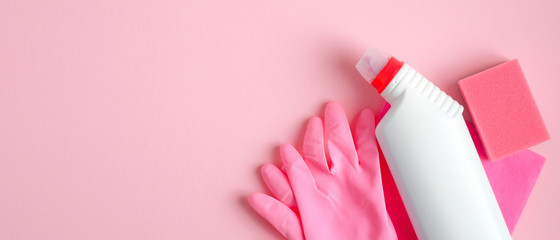 Cleaning supplies on pink background. House cleaning service and housekeeping concept. Top view...