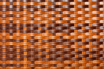 Beautiful brown pattern of artificial rattan with top and side lighting, close-up.