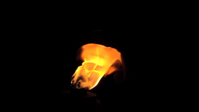 Flame of a burning torch in the dark. Flaming Torch Isolated in Pitch Black Darkness.