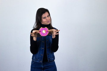 Portrait of fashionable middle age woman modelcookie pointing with fore finger the object, isolated on gray background studio shotblack sweater, denim jacket, jeans, dark air. Place for your text in c