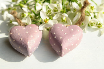 Zwei Holzherzen mit Schneeglöckchen