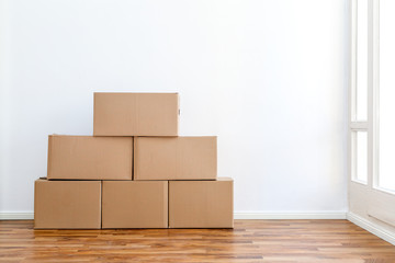 Umzugskartons in einer leeren Wohnung vor einer wei&szlig;en Wand