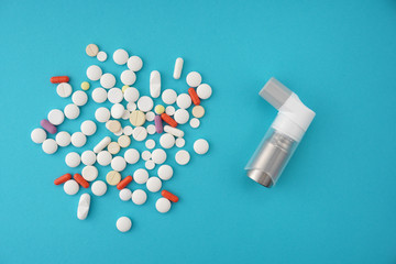 Assorted pharmaceutical medicine capsules with asthma inhaler on blue background.Medical, pharmacy...