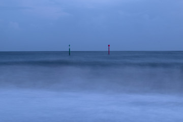 Gren and red posts in the sea