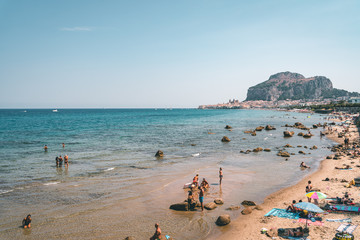 Obraz premium Cefalù, Sicily, Italy - August 22, 2019. People bathing in the Mediterranean Sea, tourists sunbathing 