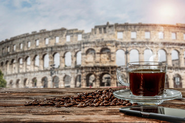 Black coffee on a wooden table in the center of Rome and free space for an advertising product