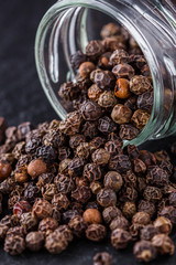 aromatic black pepper on a dark stone background