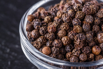 aromatic black pepper on a dark stone background