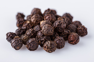 fragrant black pepper on white acrylic background