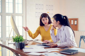 Group of young asian designer in smart casual wear talking and development ux app on mobile phone...