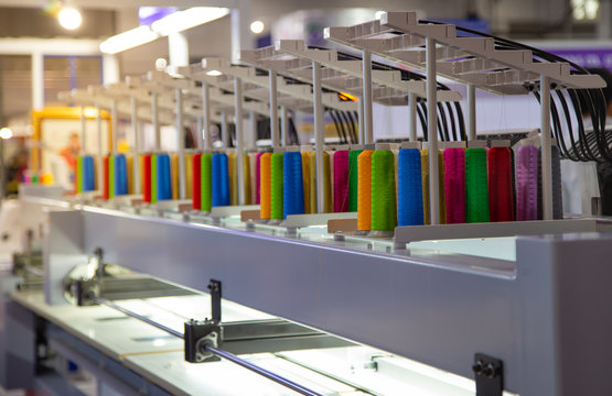Colorful rows spools of thread stand on embroidery machine