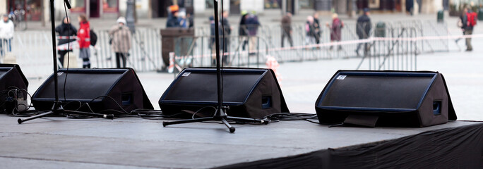 Stage monitor system, a row of stage floor monitors, three horizontal speakers on stage edge,...