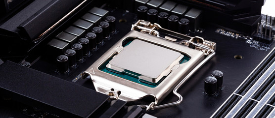 Simple silver unbranded hi end CPU in socket, surface closeup, modern motherboard wide angle product shot. Installing a new processor, hardware upgrade, before applying thermal paste abstract concept