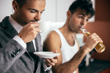 Male twins staying together in the kitchen in the morning