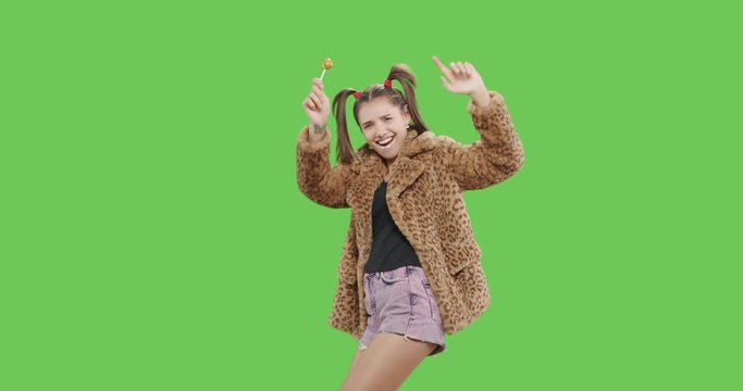 female model wearing leopard fur coat licking candy