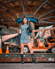 Street style, Caucasian brunette in a carousel at the fair with short skirt