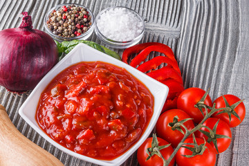 Fresh tasty tomato sauce on rustic wooden background