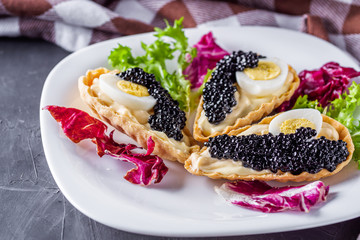 delicious snack tartlets on dark stone background
