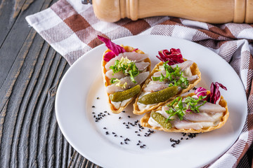 delicious snack tartlets on rustic wooden background