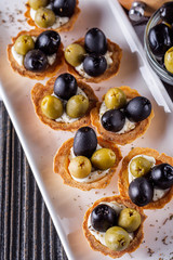 delicious snack tartlets on rustic wooden background
