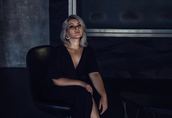 girl in a black dress dressing gown sitting in a house in a dark interior