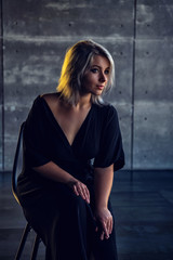 girl in a black dress dressing gown sitting in a house in a dark interior