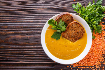 lentil cream soup on rustic wooden background